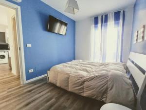 een blauwe slaapkamer met een bed en een blauwe muur bij Mandracchio Central Apartment in Grado