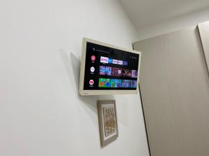 a flat screen tv on a wall next to a refrigerator at Le bougainvillea 2 in Corbetta