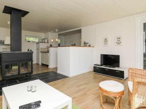 uma sala de estar com lareira e uma cozinha em 6 person holiday home in S by em Nordost