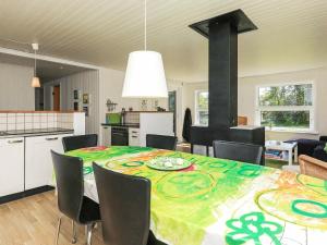 cocina y comedor con mesa y sillas en 6 person holiday home in S by en Nordost