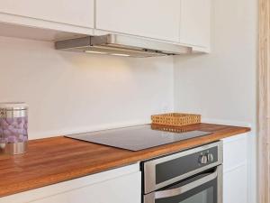 a kitchen with white cabinets and a stove top oven at 4 person holiday home in Gudhjem in Gudhjem