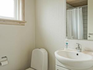 a bathroom with a sink and a toilet and a mirror at 4 person holiday home in Gudhjem in Gudhjem