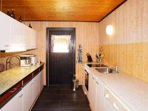 Falenにある6 person holiday home in Hemmetの白いキャビネットと黒いドア付きのキッチン