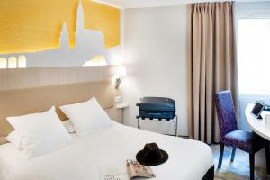 a hotel room with a bed and a desk at Hôtel Saint Sauveur in Lourdes