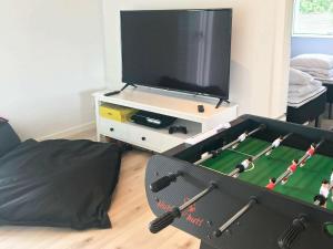 sala de estar con TV y mesa con un juego de fútbol de juguete en 14 person holiday home in V ggerl se, en Bøtø By