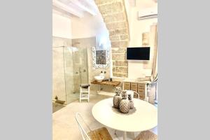 Cette chambre dispose d'une table, d'une télévision et d'une salle de bains. dans l'établissement LEMON SUITE Ortigia, à Syracuse 66 autres photos