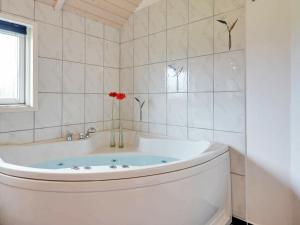 a white bath tub with a red flower in a bathroom at 6 person holiday home in Tarm in Hemmet
