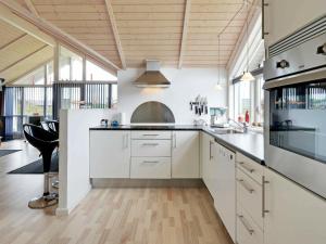 a kitchen with white cabinets and a stove top oven at 6 person holiday home in Tarm in Hemmet