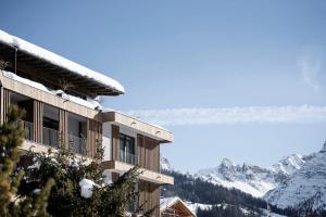 un edificio con vista sulle montagne innevate di Hotel Plan Murin a La Valle