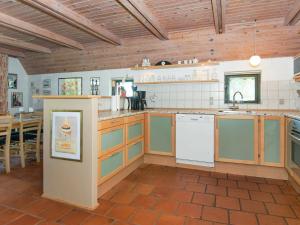 a large kitchen with wooden ceilings and a table at 8 person holiday home in Glesborg in Fjellerup