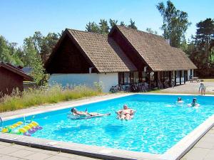a group of people swimming in a swimming pool at 6 person holiday home in Nex in Snogebæk