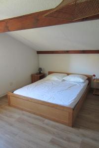 a bed in a room with a wooden bed frame at Appartement Pour 3/4 Personnes Avec Vue Sur Le Port De Plaisance- Residence Notre-Dame in Capbreton