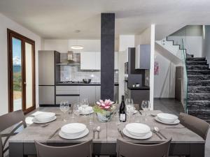 eine Küche und ein Esszimmer mit einem Tisch und Stühlen in der Unterkunft Villa Rocchi Livreri by Interhome in Scopello