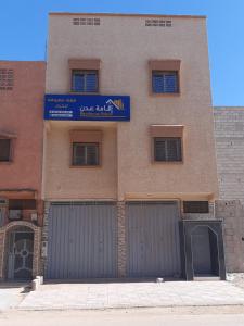 a building with two garage doors and a sign on it at Résidence Aden إقامة عدن in Laayoune