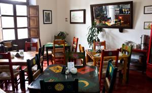 a dining room with tables and chairs and a mirror at Posada del Cafeto in Xalapa