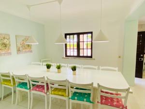 - une salle à manger blanche avec une table et des chaises blanches dans l'établissement Azinheira by Check-in Portugal, à Albufeira