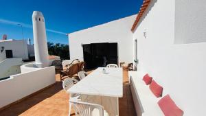 - un patio blanc avec une table et des chaises blanches dans l'établissement Azinheira by Check-in Portugal, à Albufeira