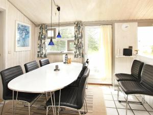 SkramにあるThree-Bedroom Holiday home in Ålbæk 20のダイニングルーム(白いテーブル、黒い椅子付)