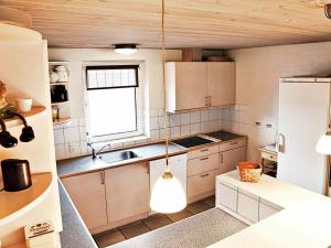 ヴィデ・サンデにある16 person holiday home in Hvide Sandeの白いキャビネットと窓付きのキッチン