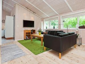 uma sala de estar com um sofá e uma mesa em Five-Bedroom Holiday home in Juelsminde 1 em Slagelse
