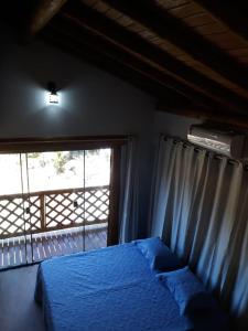 ein Schlafzimmer mit einem blauen Bett und einem Fenster in der Unterkunft Sitio Da Cachoeirinha Paraju Domingos Martins in Floriano Simmer
