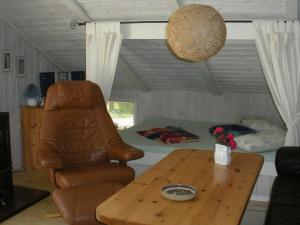 ein Wohnzimmer mit einem Tisch und einem Stuhl in der Unterkunft 4 person holiday home in Jerup in Jerup