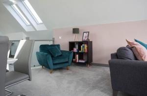 a living room with two chairs and a book shelf at Oor Neuk in Tole