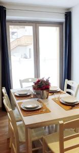 a dining room table with chairs and a table with plates at Sclap Appartamenti - Livigno in Livigno