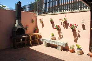 a patio with a bench and potted plants on a wall at La Casa Madrona in Villacastín