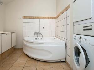 y baño con bañera blanca y lavadora. en 6 person holiday home in Egernsund, en Egernsund