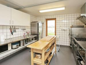 una gran cocina con una mesa de madera. en 24 person holiday home in L kken, en Grønhøj