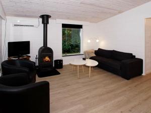 a living room with a couch and a fireplace at Three-Bedroom Holiday home in Hemmet 67 in Falen