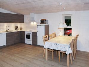 a kitchen and dining room with a table and chairs at Three-Bedroom Holiday home in Hemmet 67 in Falen