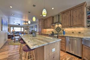 a kitchen with wooden cabinets and a large island at Updated Mtn Home with Deck on Uncompahgre River in Ouray