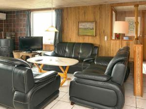 Lakolkにある6 person holiday home in R mのリビングルーム(革張りの椅子、テーブル付)