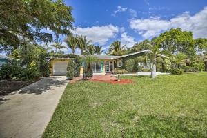 a house with a yard with a driveway at Cape Coral Home with Yard Less Than 1 Mi to Dtwn! in Cape Coral