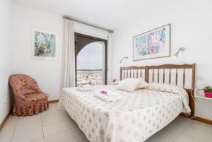 - une chambre avec un lit, une chaise et une fenêtre dans l'établissement Apart-rent Apartamento Port Grec 0161, à Empuriabrava