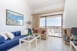 - un salon avec un canapé bleu et une table dans l'établissement Apart-rent Apartamento Port Grec 0161, à Empuriabrava
