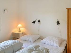 two beds in a bedroom with two lamps on the wall at Holiday Home Horns Bjerge IV in Blåvand