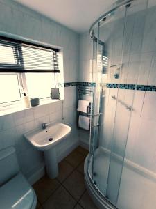 W łazience znajduje się umywalka i przeszklony prysznic. w obiekcie 35 Gower Holiday Village w mieście Reynoldston