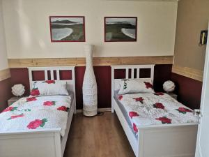 2 Betten in einem Zimmer mit roten Wänden in der Unterkunft Landhaus Galke in Hude