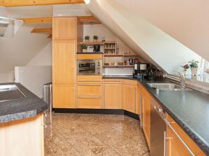 an attic kitchen with wooden cabinets and a sink at 10 person holiday home in Bramming in Bramming