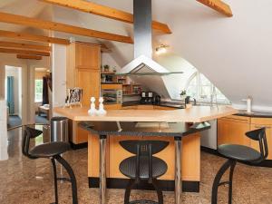 a kitchen with a large island with black bar stools at 10 person holiday home in Bramming in Bramming