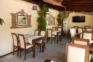 a dining room with tables and chairs and a tv at Vromos Guest Rooms in Chernomorets