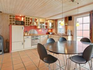 a kitchen with a table and chairs in it at 6 person holiday home in Hemmet in Falen