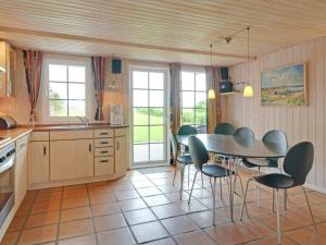 a kitchen with a dining room table and chairs at 6 person holiday home in Hemmet in Falen