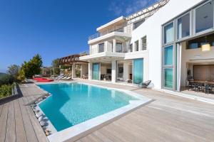 a swimming pool in the backyard of a house at Villa TakeOff Saronida in Anavyssos