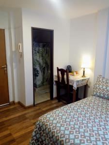 a bedroom with a bed and a desk and a table at Astoria Patagonia II habitaciones privadas in San Carlos de Bariloche