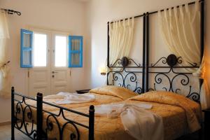 a bedroom with a bed with a black frame at Chora Resort Hotel & Spa in Chora Folegandros