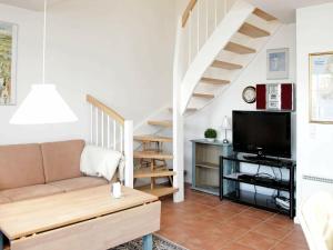 a living room with a couch and a tv at 4 person holiday home in Blåvand-By Traum in Blåvand